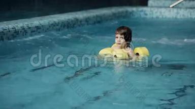 孩子们在游泳池里游泳。 小男孩在休闲中心的游泳池里游泳